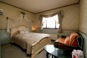 1 dormitorio con 1 cama, 1 silla y 1 ventana en Petit Resort Hotel Der Barte, en Zao Onsen