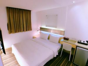 Postel nebo postele na pokoji v ubytování Meng Qi Hotel
