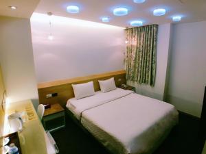a small room with a bed and a window at Meng Qi Hotel in Taipei