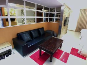 a living room with a black couch and a table at Meng Qi Hotel in Taipei