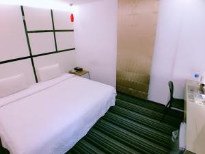a bedroom with a white bed and a green floor at Meng Qi Hotel in Taipei