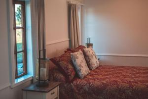 a bedroom with a bed with pillows and a window at Woodside Orchard in Greytown