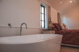 a large white tub in a room with a couch at Woodside Orchard in Greytown