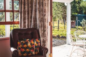 a leather chair with a quilt on a porch at Woodside Orchard in Greytown