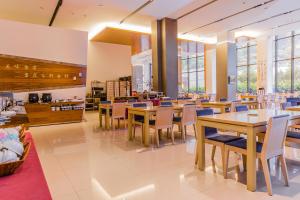 a restaurant with wooden tables and chairs and windows at Go Ya Hot Spring in Heping