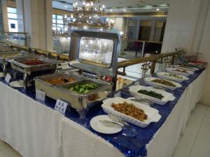 a buffet line with dishes of food on a table at Qinhuangdao Yang Cheng Hotel in Qinhuangdao