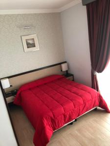 a bedroom with a red bed with a red blanket at Hotel Hermitage in Qualiano