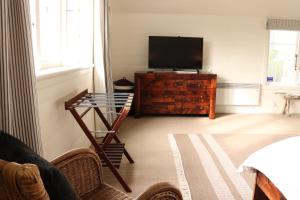 a living room with a television and a glass table at Historic Colenso Cottage in Napier