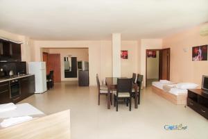 eine Küche und ein Wohnzimmer mit einem Tisch und Stühlen in der Unterkunft Aparthotel Golf Coast in Kawarna