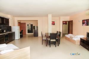 a kitchen and living room with a table and chairs at Aparthotel Golf Coast in Kavarna