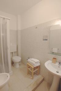 La salle de bains blanche est pourvue de toilettes et d'un lavabo. dans l'établissement Bed & Breakfast Tiziana, à Castellammare del Golfo