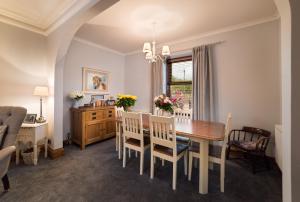 a dining room with a table and chairs at Kylelachin in Dingwall