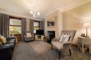 a living room with a couch and chairs and a television at Kylelachin in Dingwall