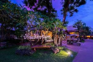 a park bench sitting in front of a building at Baan Kiang Chan Resort in Mae Sot