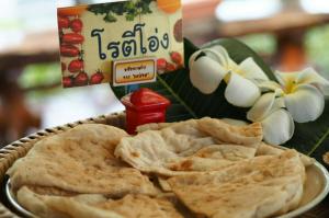 a plate of food with chips and a box of crackers at Baan Kiang Chan Resort in Mae Sot