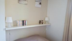 une étagère blanche sur un mur blanc avec des livres dans l'établissement tahiti parc maisonnette 6 pers 2 chambre, au Lavandou