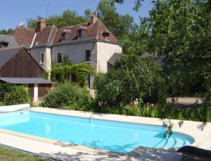 una gran piscina frente a una casa en Chambre d'Hôtes Le Moulin des Landes en Vernou-sur-Brenne
