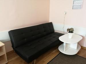 a black couch in a room with a white table at Mahtra Hostel in Tallinn