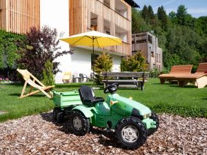 a green lawn mower parked in front of a building at Der Brückenwirt in Heinfels