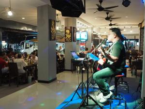 a man is playing a instrument in a restaurant at Arita Hotel Patong in Patong Beach