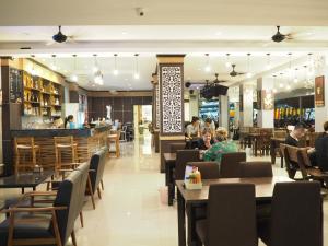 un restaurante con mesas y un bar en Arita Hotel Patong, en Patong Beach