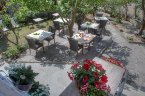 an outdoor patio with tables and chairs and flowers at Rione San Carlo in Finale Ligure