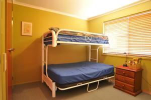 a bedroom with two bunk beds and a window at BEACHCROFT - INLET SIDE in Inverloch