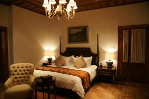 a bedroom with a bed and a chair and a chandelier at Shanghai Hengshan Moller Villa Hotel in Shanghai