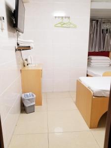آسيا ترافيل هاوس في هونغ كونغ: حمام صغير مع سرير ومرحاض