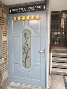 a blue door with a painting of a tree on it at Deer Park Home Stay in New Delhi