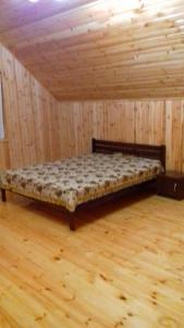 ヘニチェスカ・ヒルカにあるДуэт-коттедж ZODIAKのウッドフロアのウッドルームのベッド1台分です。