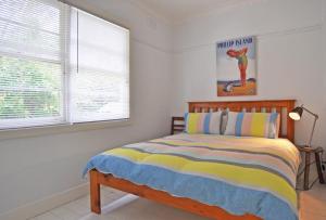 a bedroom with a bed and a window at SEA WHISPERS - INLET SIDE in Inverloch