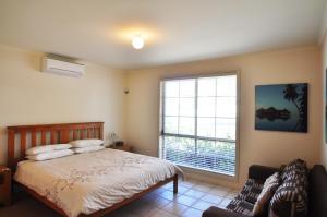 a bedroom with a bed and a large window at SEAHOLME - WIFI & FOXTEL in Inverloch