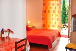 1 dormitorio con cama roja y ventana en Apartments Franic, en Ploče
