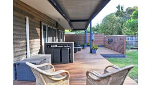 a porch with two wicker chairs and a table at SURF PLAZU - SURF SIDE in Inverloch