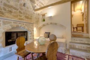 a living room with a table and a fireplace at Ritsos Guesthouse in Monemvasia