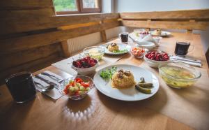 a table with plates of food and bowls of fruit at Vovk Gasthaus in Sinyak
