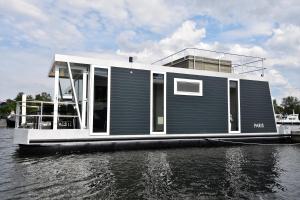 un bateau dans l'eau sur une rivière dans l'établissement Cosy floating boatlodge, "Paris", à Maastricht