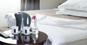 a coffee maker on a table next to a bed at Bungalouri La Mare*** Saturn in Mangalia
