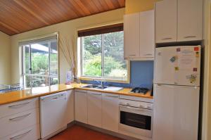 a kitchen with white cabinets and a white refrigerator at THE SAILS 4 - CENTRAL LOCATION in Inverloch