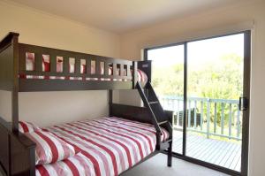 a bedroom with a bunk bed and a balcony at WAVELENGTH - WIFI & PET FRIENDLY (OUTSIDE ONLY) in Inverloch