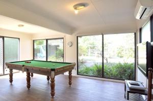 a pool table in a room with windows at WAVELENGTH - WIFI & PET FRIENDLY (OUTSIDE ONLY) in Inverloch