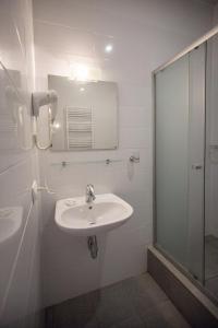 a white bathroom with a sink and a shower at Vovk Gasthaus in Sinyak +24 photos