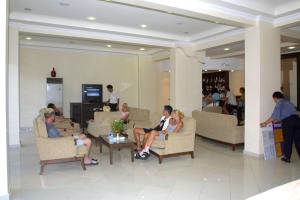 um grupo de pessoas sentadas em cadeiras em um lobby em Alin Hotel em Alanya