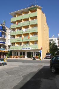 een groot gebouw met een auto voor de deur bij Alin Hotel in Alanya