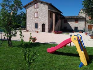 a slide in the grass in front of a house at Agriturismo"Il Sagrato di Assisi" appartamenti,camere in Assisi