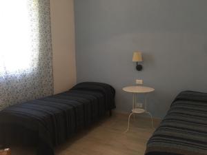 マルツァメミにあるForte Villageのベッド2台、テーブル、窓が備わる客室です。