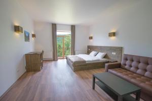 ein Wohnzimmer mit einem Bett und einem Sofa in der Unterkunft Vovk Gasthaus in Synjak