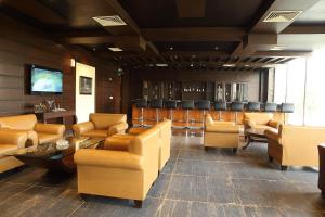 a waiting room with couches and chairs and a bar at Defence Raya Golf & Country Club in Lahore