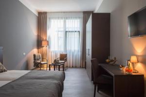 een hotelkamer met een bed en een bureau bij Hotel Bladel in Bladel